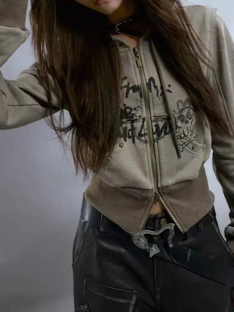 Kısa fermuarlı hoodie üzerinde grunge grafik desenleri.