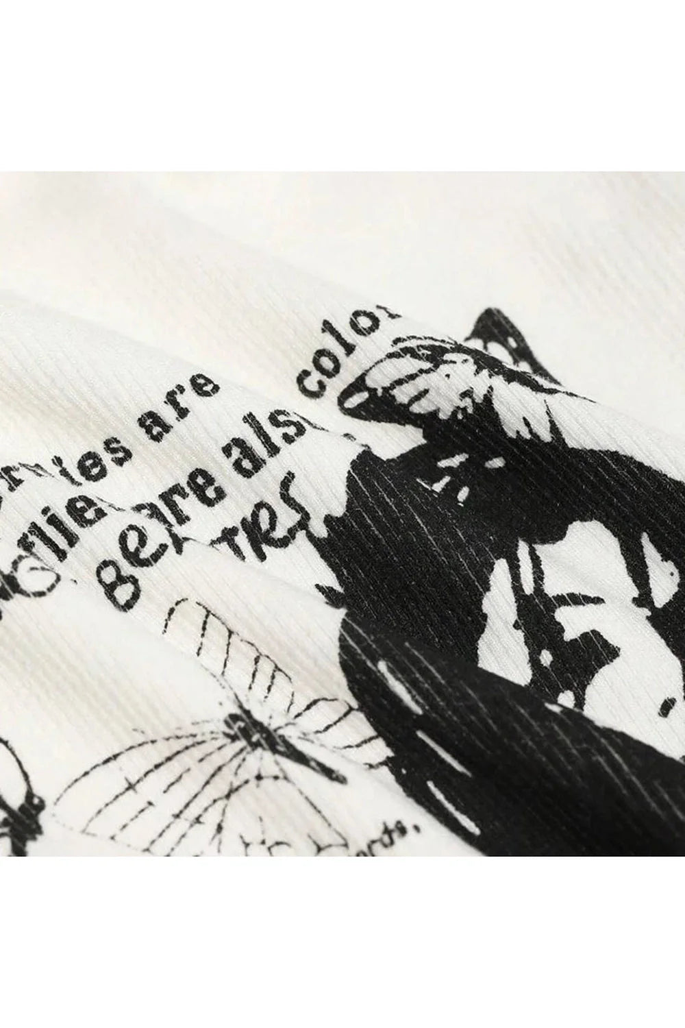 Kelebek desenli grunge tarzı grafik üst, asi bir hava sunar.