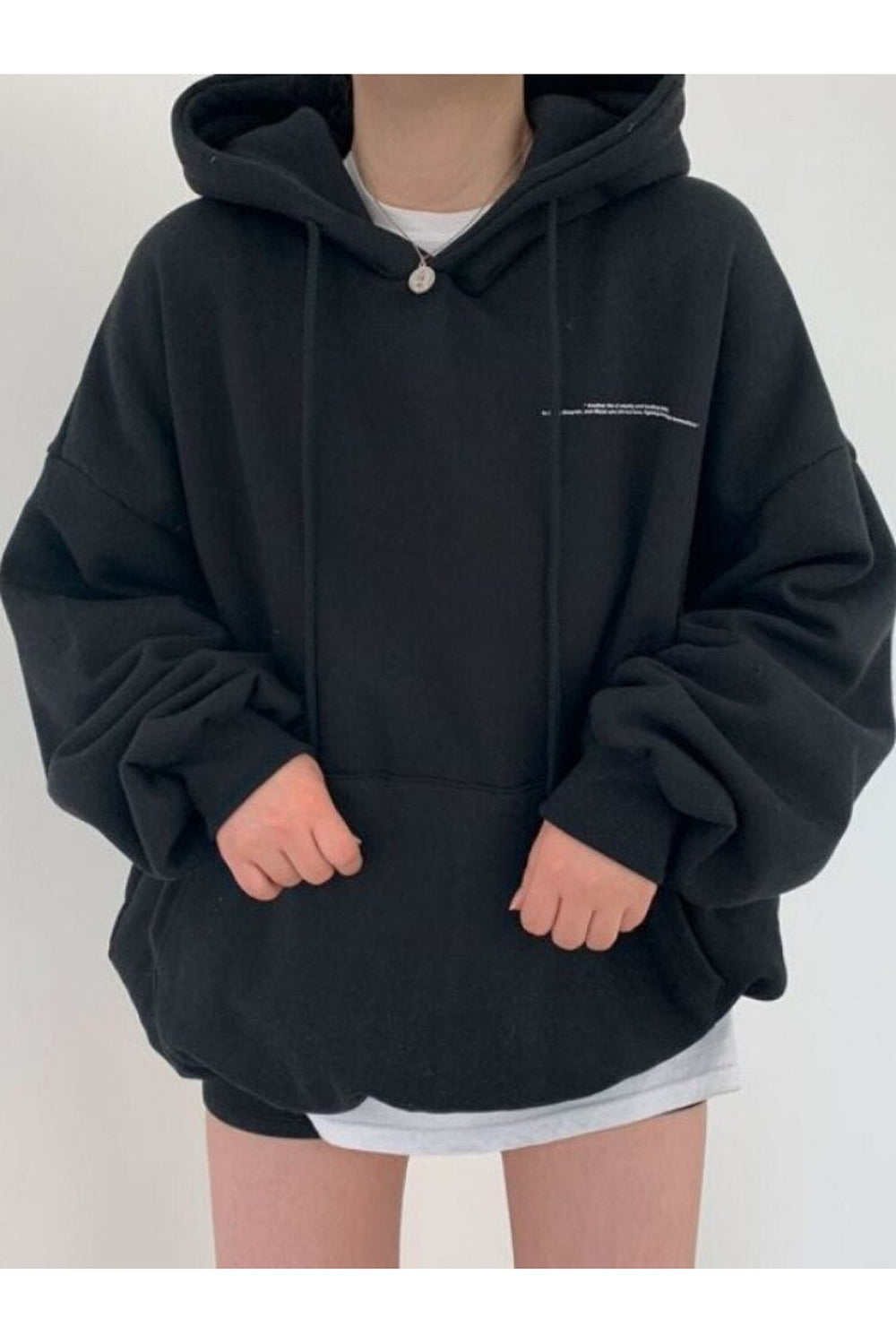 Sonbahar rüzgarlarında özgürce hareket eden geniş kesim harf desenli hoodie.