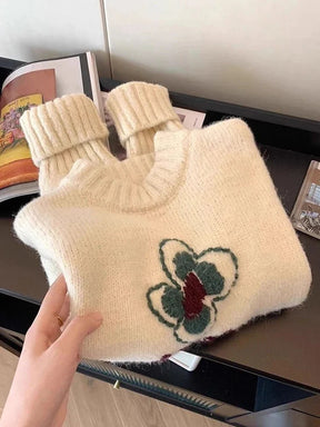Nakışlı çiçek desenleriyle süslenmiş örgü kazak.