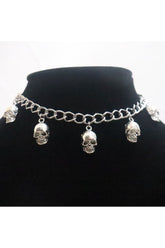 Gotik tarzda metal kolye, kuru kafayı yansıtıyor.