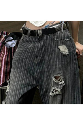 Grunge tarzını yansıtan yırtık detaylı çizgili pantolon.