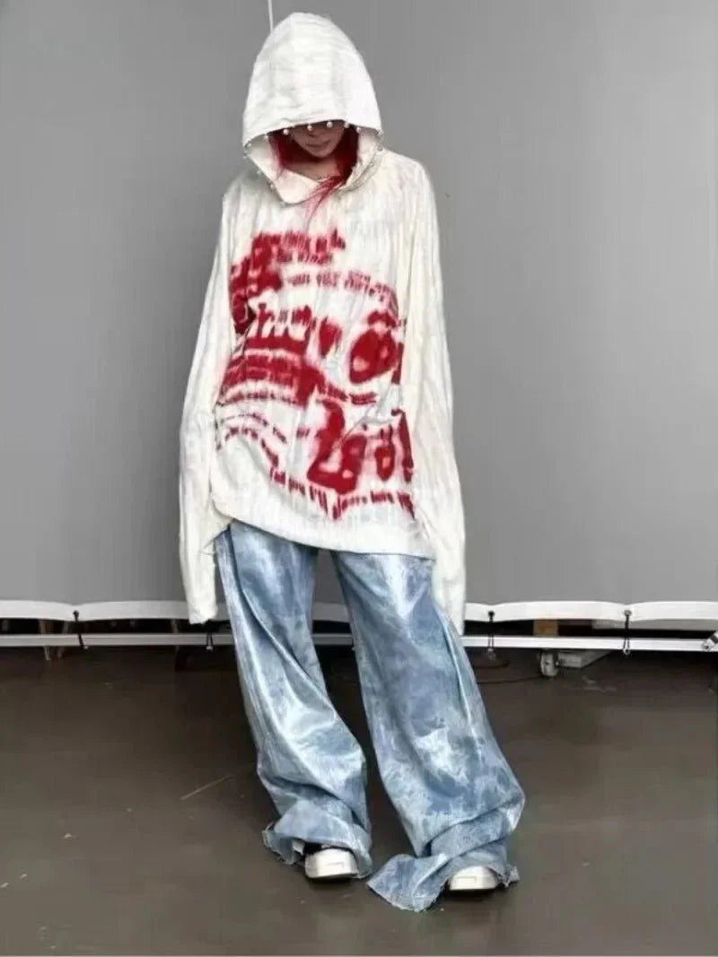 Grafiti tarzında desenli kapüşonlu sweatshirt, sokak modasına yansıyor.