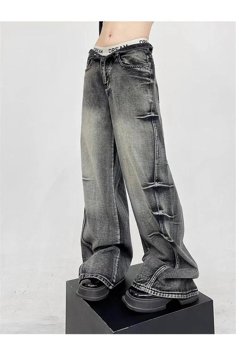 Geniş kesimli yüksek bel pantolon, grunge tarzını yansıtıyor.