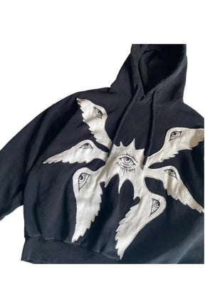 Sonbahar manzaralı, gizemli göz nakışlarıyla süslenmiş hoodie.