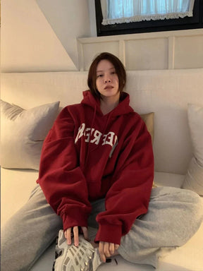 Oversize kesimli bordo grafik hoodie, rahat ve şık bir görünüm sunar.
