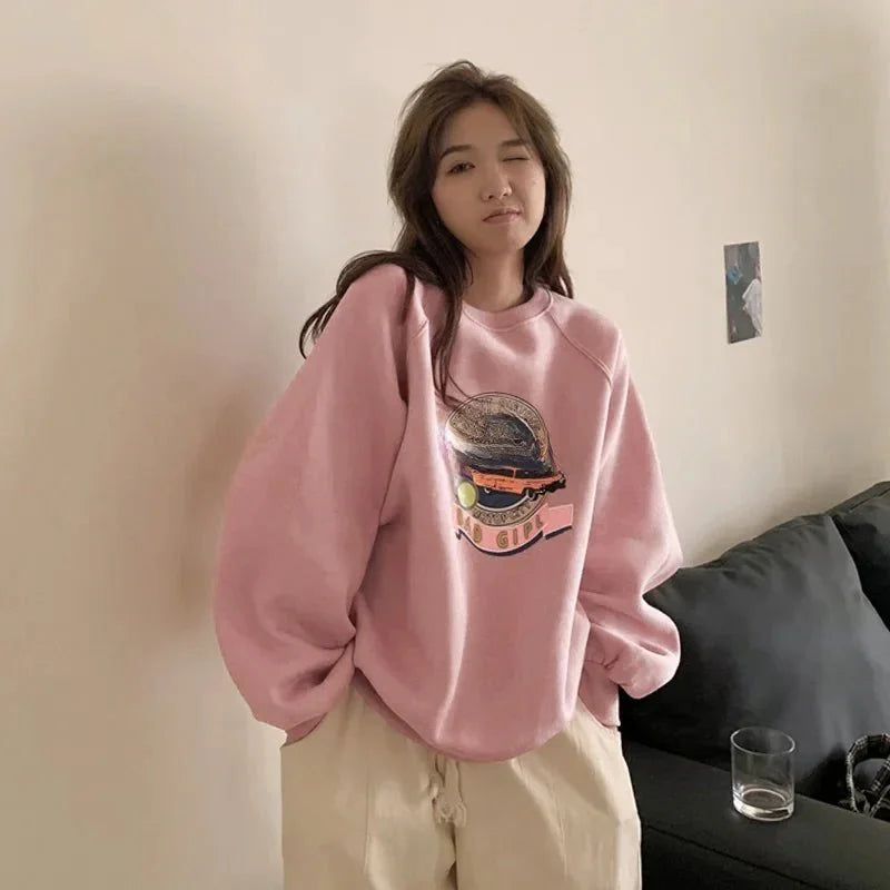 Pastel pembe tonlarında grafik desenli sweatshirt rahat ve şık.