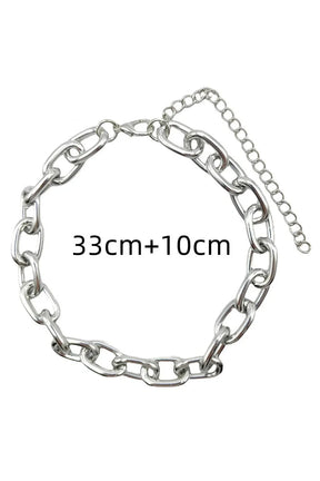 Kalın zincirli choker, punk tarzını vurgular.