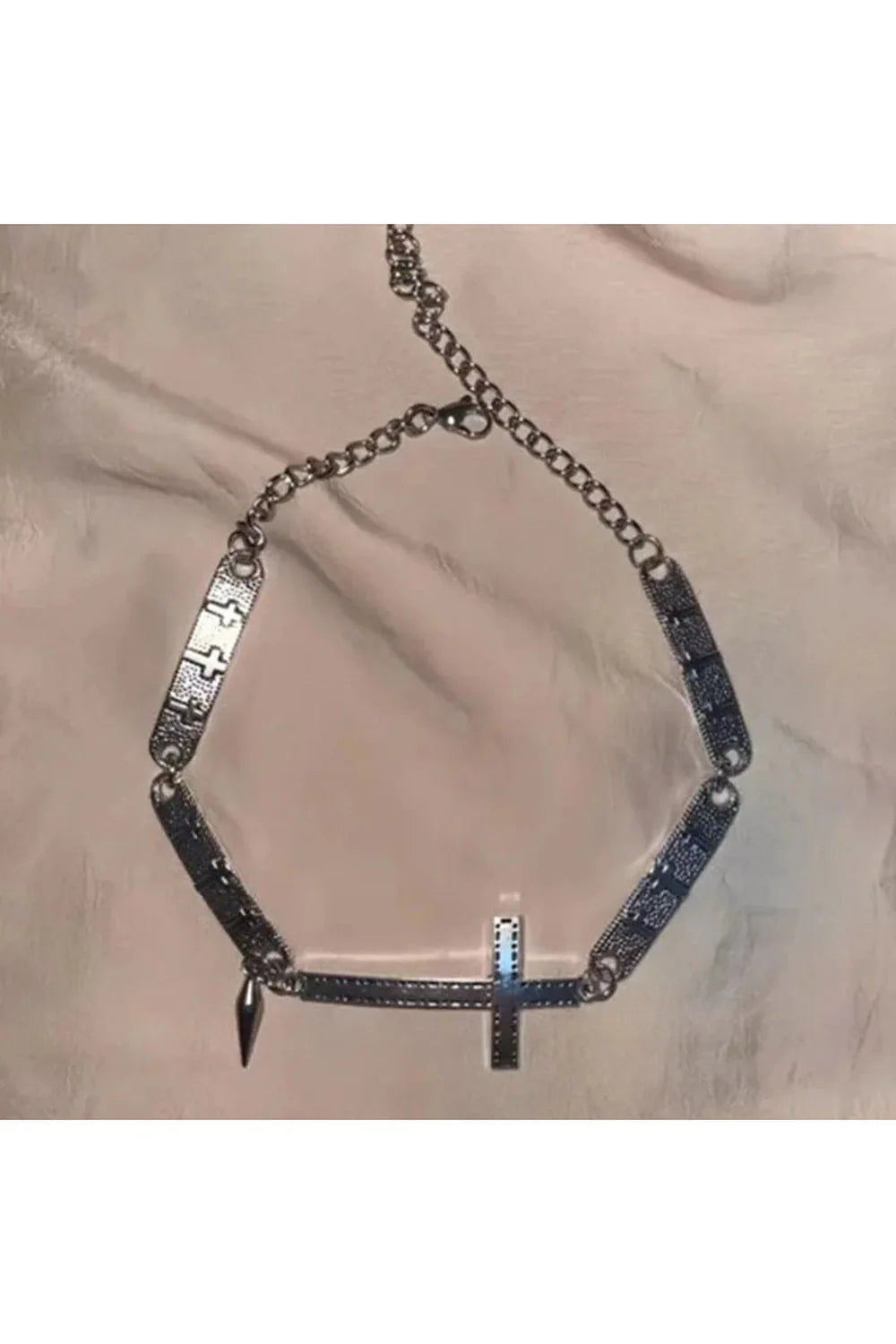 Gümüş tonlarında, dikenli haç detaylı choker kolye.