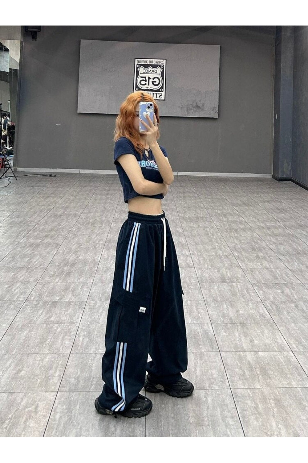 çizgili desenli rahat eşofman altı, spor şıklığı vurgular.