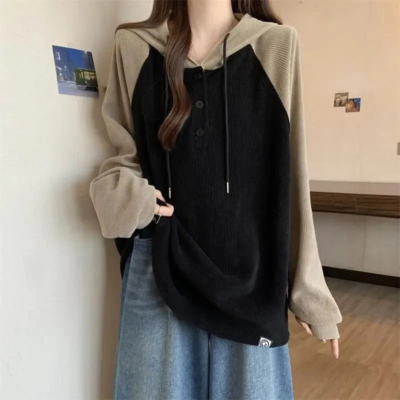 iki tonlu sweatshirt, düğmeli kapüşon detayıyla.